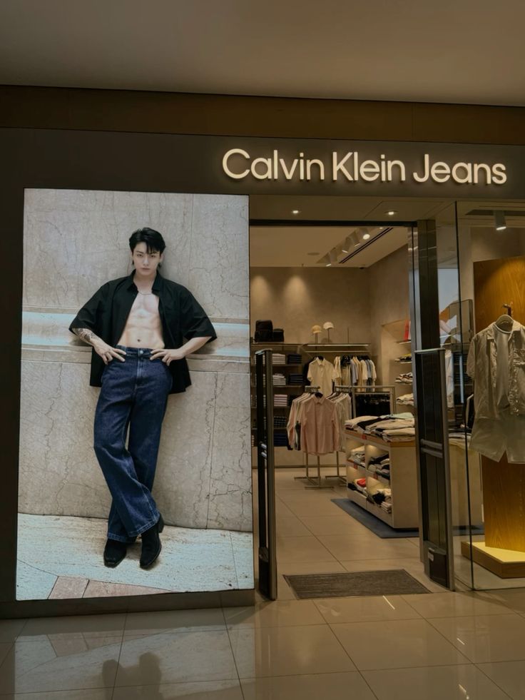 Exterior view of a Calvin Klein Jeans store in Singapore, showcasing contemporary architecture and BTS-themed advertising.Jungkook