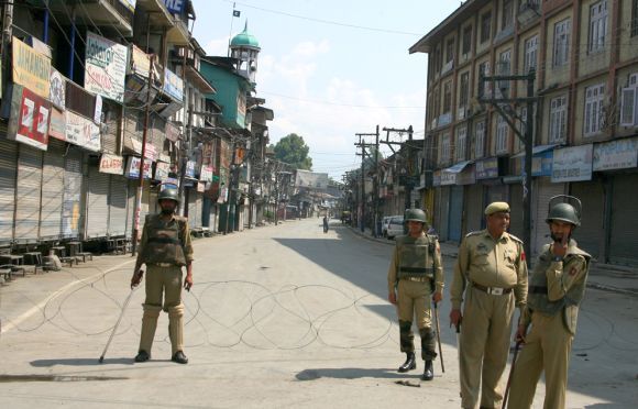Policemen monitor the street in Srinagar after the recent Pahalgam Kashmir terror attack.