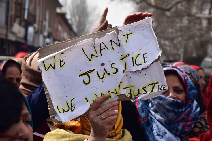 In Pahalgam, Kashmir, a woman displays a sign that says "We want justice" at a rally after a terror attack.