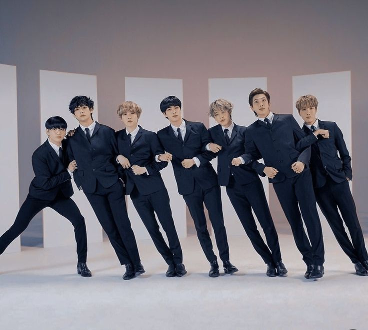 BTS members, a group of Asian men in suits, smiling and posing for a photo together.