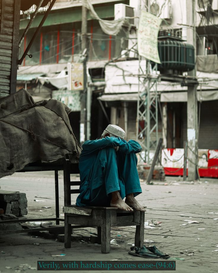 A man on a bench in a city, under dark clouds, symbolizes the tension from India's water strike affecting Pakistan.